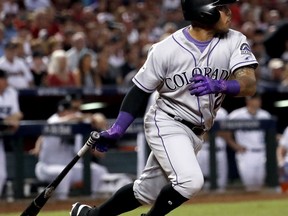 Colorado Rockies' Alexi Amarista follow through on an RBI base hit against the Arizona Diamondbacks during the fourth inning of the National League wild-card playoff baseball game, Wednesday, Oct. 4, 2017, in Phoenix. (AP Photo/Matt York)