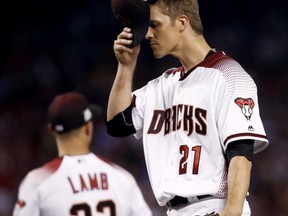 Arizona Diamondbacks starting pitcher Zack Greinke (21) adjusts his cap after giving up a base hit during the third inning of game 3 of baseball's National League Division Series against the Los Angeles Dodgers, Monday, Oct. 9, 2017, in Phoenix. (AP Photo/Ross D. Franklin)