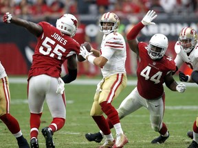 San Francisco 49ers quarterback Brian Hoyer looks to throw as Arizona Cardinals outside linebacker Markus Golden (44) and outside linebacker Chandler Jones (55) pursue during the second half of an NFL football game, Sunday, Oct. 1, 2017, in Glendale, Ariz. (AP Photo/Ross D. Franklin)