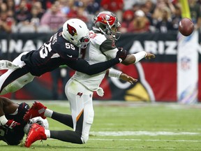 Tampa Bay Buccaneers quarterback Jameis Winston, right, is tackled by Arizona Cardinals outside linebacker Chandler Jones (55) and inside linebacker Haason Reddick (43) during the first half of an NFL football game Sunday, Oct. 15, 2017, in Glendale, Ariz. Winston was injured on the play, would briefly return to the game, but left the game before halftime. (AP Photo/Ralph Freso)