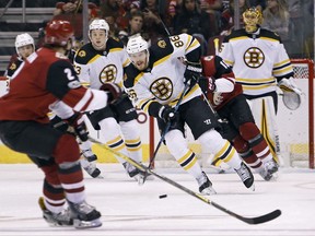 Boston Bruins' Kevan Miller (86) advances the puck up ice against the Arizona Coyotes during the first period of an NHL hockey game, Saturday, Oct. 14, 2017, in Glendale, Ariz. (AP Photo/Ralph Freso)