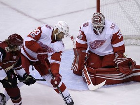 Detroit Red Wings right wing Anthony Mantha (39) makes a save against Arizona Coyotes center Christian Dvorak (18) as Trevor Daley (83) defends in the first period during an NHL hockey game, Thursday, Oct. 12, 2017, in Glendale, Ariz. (AP Photo/Rick Scuteri)