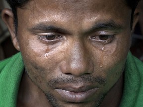 In this Sept. 30, 2017, photo tears roll down the cheeks of Rohingya man Alam Jafar as he recounts the story of his journey from Myanmar to Bangladesh, at a transit shelter at Kutupalong camp for newly arrived Rohingya refugees in Bangladesh.