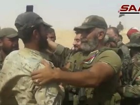 This frame grab from a video released on September 5, 2017 by the Syrian official news agency SANA, shows Syrian army senior commander Brig. Gen. Issam Zahreddine, right, who led the fight against Islamic Sate militants in the eastern city of Deir el-Zour congratulates a Syrian army soldier, at a front line, in Deir el-Zour, Syria. The Central Military Media said on Wednesday, Oct. 18, 2017, that Zahreddine was killed in Hawija Saqr, east of Deir el-Zour, in operations against IS militants. (SANA via AP)