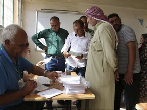In this picture taken on Sept. 22, 2017 and provided by the Press Office of the Kurdish Self-administration Office in Kobani, Kurdish citizens, right, receive ballot papers to elect new local councils of the three Kurdish-administered areas in northern Syria, known as Rojava, at a polling station, in Kobani, Syria. While While Iraq's Kurds have sparked confrontation with their drive for independence, Kurds in Syria are making major advances toward their more modest goal, entrenching their self-rule.(Rania Mohammed, Press Office of the Kurdish Self-administration Office in Kobani via AP)
