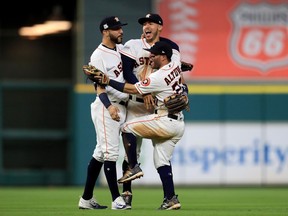 Houston Astros infielders Marwin Gonzalez (left), Carlos Correa (centre) and Jose Altuve celebrate their win in Game 7 of the ALCS against the New York Yankees on Oct. 21.