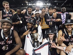 In this March 12 file photo, Carleton Ravens players celebrate their seventh straight national basketball title — and 13th in the last 15 years — in Halifax.