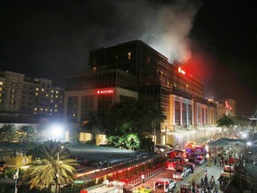 FILE - In this Friday, June 2, 2017, file photo, smoke rises from an attack inside the Resorts World Manila complex in suburban Pasay city, southeast of Manila, Philippines. Across the globe, risks of terrorism and other violence have made tight security at hotels and resorts routine. The most recent major attack in Asia, at the Resorts World Manila casino in the Philippines, shares similarities with the shooting Sunday night in Las Vegas that killed 59 and injured more than 500 people. (AP Photo/Bullit Marquez, File)
