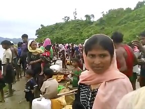 In this Oct. 5, 2017, video released by Arakan Rohingya National Organization, villagers are seen preparing to cross a river towards  the Maungdaw township in the Rakhine state that borders Bangladesh. More Rohingya Muslims fleeing violence in Myanmar are streaming toward the border, despite government assurances that it is stopping the exodus of refugees to Bangladesh. (Arakan Rohingya National Organization via the AP)