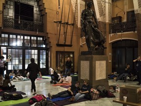 FILE - In this Saturday, Sept. 30 2017 photo, people prepare to spend the night inside a school listed to be a polling station by the Catalan government in Barcelona, Spain. (AP Photo/Felipe Dana, File)