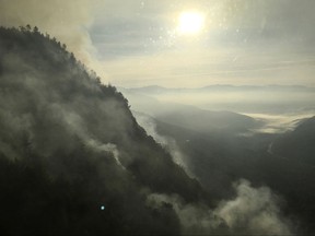In this photo released Wednesday, Oct. 4, 2017, smoke rises from a brush fire in North Woodstock, N.H. The fire forced closure of Lost River Gorge, an area popular with hikers and explorers, before one of the busiest autumn leaf-watch weekends. The fire started Tuesday on a cliff in Kinsman Ridge over the gorge. (New Hampshire Division of Forests and Lands via AP)