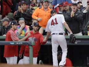 Boston Red Sox relief pitcher Chris Sale (41) is congratulated at the dugout by pitchers Doug Fister, left, and Rick Porcello, center, who started the game, at the end of the top of the fifth inning of Game 4 of baseball's American League Division Series against the Houston Astros, Monday, Oct. 9, 2017, in Boston. (AP Photo/Charles Krupa)