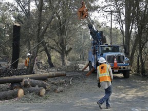 A Pacific Gas & Electric crew work on replacing poles Wednesday, Oct. 18, 2017, in Glen Ellen, Calif. California fire officials have reported significant progress on containing wildfires that have ravaged parts of Northern California. (AP Photo/Ben Margot)