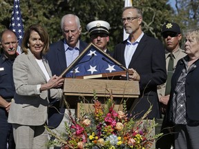 Minority Leader Nancy Pelosi, D-Calif., second from left, along with Rep. Mike Thompson, D-Calif., third from left, Rep. Zoe Lofgren, D-Calif., right, and Rep. Jared Huffman, D-Calif., third from right, present a U.S. flag which was flown over the Capitol to Santa Rosa fire chief Tony Gossner during a Day of Remembrance memorial for victims of California wildfires on Saturday, Oct. 28, 2017, in Santa Rosa, Calif. (AP Photo/Ben Margot)