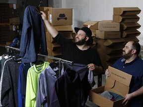 In this Friday, Aug. 11, 2017, photo, co-owners Daniel Franzese, left, and Wil Cuadros select clothes for "The Winston Box" at their showroom in Gardena, Calif. The Winston Box is a monthly subscription box that designs and makes its own clothes for big guys. More online retailers are chasing after plus-sized men, selling big sizes of slim-cut jeans, faux leather jackets and other trendy clothing that can be hard to find at the local big and tall store. (AP Photo/Damian Dovarganes)