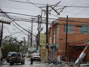 FILE - In this Wednesday, Sept. 20, 2017 file photo, power lines are down after the impact of Hurricane Maria, which hit the eastern region of the island in Humacao, Puerto Rico. In the wake of Hurricane Maria, Facebook pledged to send a "connectivity team" to help restore communications in ravaged Puerto Rico. It's just one of several tech companies - among them Tesla, Google, Cisco, Microsoft and a range of startups - with their own disaster response proposals, most aimed at getting phone and internet service up and running. (AP Photo/Carlos Giusti, File)