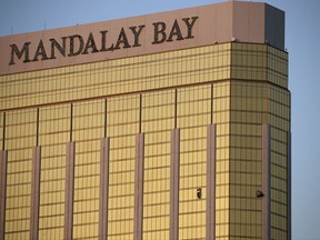 FILE - In this Monday, Oct. 2, 2017 file photo, drapes billow out of broken windows at the Mandalay Bay resort and casino on the Las Vegas Strip, following a deadly shooting at a music festival in Las Vegas. Two hotel employees had called for help and reported that gunman Stephen Paddock sprayed a hallway with bullets, striking an unarmed security guard in the leg, several minutes before Paddock opened fire from the resort on a crowd below at a musical performance, killing dozens of people and injuring hundreds. (AP Photo/John Locher, File)
