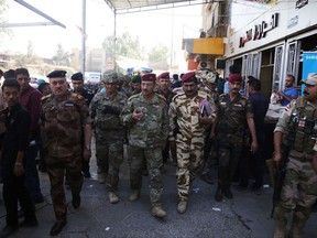 In this Oct. 4, 2017 photo released by the U.S. Army, Lt. Gen. Paul Funk, left, commanding general of Combined Joint Task Force-Operation Inherent Resolve, and Iraqi Maj. Gen. Najm Abdullah al-Jibouri, right, commander of the Nineveh Liberation Operation, walk through a busy market near the University of Mosul. In an interview with the Associated Press, the top U.S. General in Iraq says fallout from the controversial Kurdish referendum is continuing to divert resources and assets from the fight against the Islamic State group, just as the country is on the brink of militarily destroying the extremists. (Spc. Avery Howard, U.S. Army via AP)