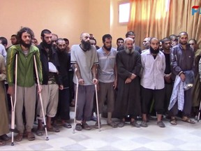 FILE - This file frame grab from video released Sunday, Oct. 15, 2017 and provided by Furat FM, a Syrian Kurdish activist-run media group, shows Syrian Islamic State group fighters who have surrendered, at a base of the U.S.-backed Syrian Democratic Forces (SDF), in Raqqa, Syria. IS, the ultra-extremist group responsible for some of the worst atrocities perpetrated against civilians in recent history, is on the verge of collapse. The group that brutalized residents living under its command for more than three years is fighting to hang on to remaining pockets of territory in Iraq and Syria, besieged by local forces from all sides. (Furat FM, via AP, File)