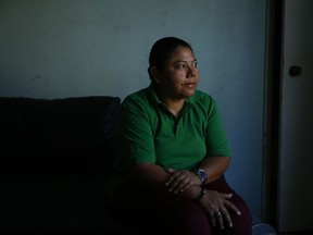 In this Wednesday, Oct. 18, 2017, photo, Iris Acosta, a 51-year-old hotel housekeeper from Honduras, pauses for photos in her sister's apartment in Los Angeles. Acosta is a Temporary Protected Status recipient, a program that is geared toward countries ravaged by natural disasters or war. The program is a temporary fix for immigrants without legal status, designed to avoid the scenario of the government deporting large numbers of immigrants to countries reeling from earthquakes, hurricanes and war. (AP Photo/Jae C. Hong)