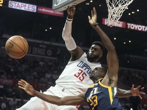 Los Angeles Clippers center Willie Reed, left, fouls Utah Jazz forward Ekpe Udoh during the first half of an NBA basketball game Tuesday, Oct. 24, 2017, in Los Angeles. (AP Photo/Kyusung Gong)