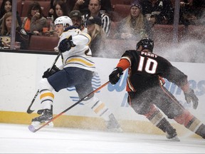 Buffalo Sabres center Sam Reinhart, left, controls the puck as Anaheim Ducks right wing Corey Perry defends him during the first period of an NHL hockey game in Anaheim, Calif. Sunday, Oct. 15, 2017. (AP Photo/Kyusung Gong)