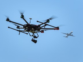A drone flies as an airplane is seen in the background.