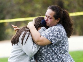 Maria Ortiz consoles her 5th-grade daughter, Crystal Godinez, after she was released from evacuation at Castle View Elementary School in Riverside, Calif., on Tuesday, Oct. 31, 2017. School officials say all students are accounted for as a man continues to hold someone hostage inside a Southern California elementary school.  (Watchara Phomicinda/The Press-Enterprise via AP)