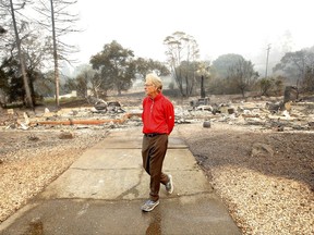 Mike Rippey walks away from the burned out remains of his parents home at the Silverado Resort, Tuesday, Oct. 10, 2017, in Napa, Calif. Charles Rippey, 100 and his wife Sara, 98, died when wind whipped flames swept through the area Sunday night. (AP Photo/Rich Pedroncelli)