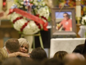 A mourner hugs family members during a memorial service for Jack Beaton at St. Elizabeth Ann Seton Catholic Church in Bakersfield, Calif., on Saturday, Oct. 7, 2017. Beaton was a victim of the Oct. 1 mass shooting in Las Vegas. (AP Photo/Silvia Flores)