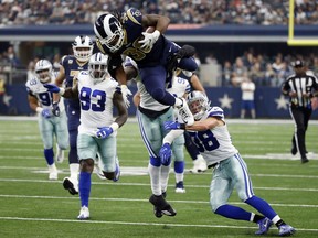 Los Angeles Rams running back Todd Gurley (30) is stopped by Dallas Cowboys linebacker Jaylon Smith, rear, and safety Jeff Heath (38) after Gurley lept over Heath on a carry in the second half of an NFL football game, Sunday, Oct. 1, 2017, in Arlington, Texas. (AP Photo/Michael Ainsworth)