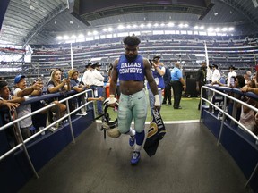 Dallas Cowboys running back Ezekiel Elliott (21) walks off the field holding the jersey of Los Angeles Rams running back Todd Gurley after their NFL football game, Sunday, Oct. 1, 2017, in Arlington, Texas. (AP Photo/Ron Jenkins)