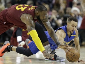 FILE - This Sunday, Dec. 25, 2016 file photo shows Cleveland Cavaliers' LeBron James, left, and Golden State Warriors' Stephen Curry battling for a loose ball in the second half of an NBA basketball game, in Cleveland. The Warriors and Cavaliers are being penciled in to meet in the NBA Finals once again. They're going to drive most of the conversation this season, a fact that is not lost on the league or its TV partners. When the season tips off Tuesday, Cleveland will take the center stage first, followed by the Warriors. (AP Photo/Tony Dejak, File)