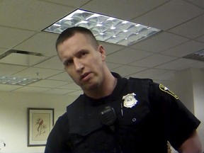 FILE - In this April 13, 2017, file image taken from video provided by the Euclid Police Department, Euclid police officer Michael Amiott stands in a public library in Euclid, Ohio. Authorities say Amiott, a white police officer who punched a black man more than a dozen times in a traffic stop outside Cleveland, was fired for use of excessive force, insubordination, unbecoming conduct and other rule violations. (Euclid Police Department via AP, File)