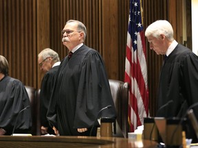 FILE - In this July 18, 2017 file photo, Chief Justice Lawton Nuss, third from left, lead justices to their seats to hear arguments on a school funding case before the Kansas Supreme Court in Topeka, Kan. The Court ruled Monday, Oct. 2, 2017, that legislators did not increase spending on the state's public schools enough this year, hinting in its opinion that lawmakers fell hundreds of millions of dollars short a year of providing a suitable education for every child. The court rejected the state's arguments that a new law phasing in a $293 million increase in funding over two years was enough to provide a suitable education for each of the state's 458,000 students. (AP Photo/Orlin Wagner File)
