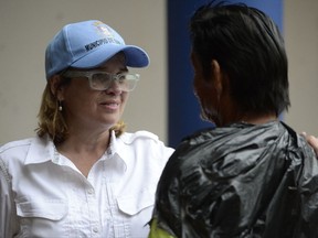 Mayor Carmen Yulin Cruz speaks with a man as she arrives at San Francisco hospital in the Rio Piedras area of San Juan, Puerto Rico, Saturday, Sept. 30, 2017, as about 35 patients are evacuated after the failure of an electrical plant. (AP Photo/Carlos Giusti)