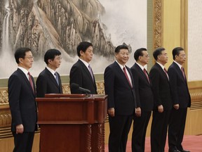 Members of the Communist Party of China's new Politburo Standing Committee Han Zheng, from left, Wang Huning, Li Zhanshu, Xi Jinping, China's president, Li Keqiang, Wang Yang and Zhao Leji stand on stage in the East Hall of the Great Hall of the People in Beijing, China, on Wednesday, Oct. 25, 2017. Chinese President Xi Jinping unveiled a new leadership line-up that included no clear potential heirs, breaking with a quarter-century-old succession system and raising the chances that he might seek to stay in office beyond 2022.