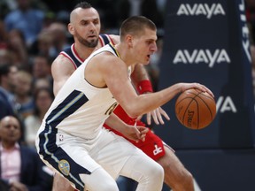 Denver Nuggets center Nikola Jokic, front, of Serbia, fields a pass as Washington Wizards center Marcin Gortat, of Poland, defends in the first half of an NBA basketball game, Monday, Oct. 23, 2017, in Denver. (AP Photo/David Zalubowski)