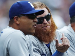 Los Angeles Dodgers third baseman Justin Turner, right, confers with manager Dave Roberts as they look on from the dugout rail in the first inning of a baseball game against the Colorado Rockies Sunday, Oct. 1, 2017, in Denver. (AP Photo/David Zalubowski)