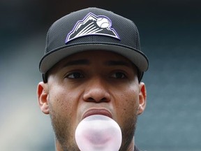 Colorado Rockies shortstop Alexi Amarista blows a bubble with his gum around the cage as the team takes batting practice before facing the Los Angeles Dodgers in a baseball game Saturday, Sept. 30, 2017, in Denver. (AP Photo/David Zalubowski)