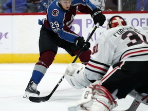 Colorado Avalanche center Nathan MacKinnon, back, fires the puck at Chicago Blackhawks goalie Anton Forsberg, of Sweden, in the first period of an NHL hockey game Saturday, Oct. 28, 2017, in Denver. (AP Photo/David Zalubowski)