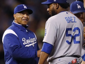 Los Angeles Dodgers manager Dave Roberts, left, smiles as he takes the ball from relief pitcher Pedro Baez as he is pulled form the mound after retiring Colorado Rockies' Ryan McMahon in the eighth inning of a baseball game Saturday, Sept. 30, 2017, in Denver. The Dodgers won 5-3. (AP Photo/David Zalubowski)
