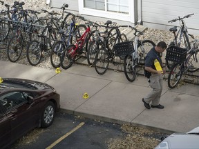 An investigator marks evidence while working the scene of an early morning homicide Thursday,, Oct. 19, 2017, in Fort Collins, Colo. The fatal shooting took place outside a housing complex about a mile west of Colorado State University. (Timothy Hurst /The Coloradoan via AP)