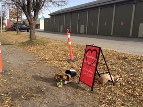 A memorial sign and flowers sits outside Fernie Memorial Arena in Fernie, B.C. on Wednesday, Oct.18, 2017. Residents who were forced from their homes because of a deadly ammonia leak at an ice rink in Fernie, B.C., are being allowed back home. THE CANADIAN PRESS/Lauren Krugel