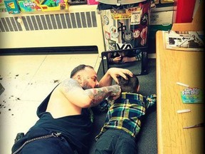 A barber from western Quebec is drawing widespread praise for going out of his way to accommodate a young client with autism. This handout photo, posted online last week, shows Francis "Franz" Jacob lying on the floor of his Rouyn-Noranda shop as he gives a young boy named Wyatt a haircut. THE CANADIAN PRESS/HO-Franz Jacob, *MANDATORY CREDIT*