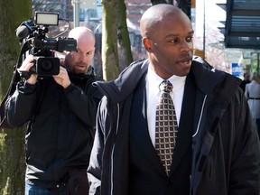 RCMP Const. Kwesi Millington, right, leaves court during a lunch break at his perjury trial in Vancouver, B.C., on Monday March 10, 2014. The Supreme Court of Canada has dismissed appeals from two men convicted of perjury in connection with a notorious Taser death at Vancouver???s airport in 2007. THE CANADIAN PRESS/Darryl Dyck