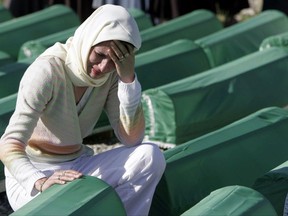 A Bosnian Muslim woman weeps near the body of a relative during a mass funeral for 350 Bosnian Muslims and 4 Bosnian Catholics killed at the beginning of the Bosnian war, in the village of Rizvanovici, Thursday, July 20, 2006. All victims were killed on July 20, 1992 during an offensive by Bosnian Serbs that left more than 4,000 missing persons. A man accused of committing crimes against humanity in the former Yugoslavia is fighting a federal move to strip his Canadian citizenship. THE CANADIAN PRESS/AP-Amel Emric