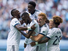 Vancouver Whitecaps' Bernie Ibini, from left, Tony Tchani, Alphonso Davies, Tim Parker and Yordy Reyna celebrate Tchani's tying goal against the Columbus Crew during the second half of an MLS soccer game in Vancouver on September 16, 2017. With a playoff berth already secured, the Vancouver Whitecaps now have their sights set on a couple of bigger prizes. The club sits first in Major League Soccer's Western Conference heading into Saturday's road game against the New York Red Bulls, knowing a victory will lock up a first-round bye and home-field advantage in the semifinals. THE CANADIAN PRESS/Darryl Dyck