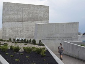 A crew member walks toward the National Holocaust Monument before the official opening in Ottawa, Wednesday September 27, 2017. Snowy days in the national capital could force the closure of the just opened National Holocaust Monument. THE CANADIAN PRESS/Adrian Wyld