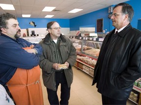 Former anti-biker cop Guy Ouellette (right) greets voters in a meat shop in Laval, Que. March 1, 2007. From policing to politics, much of Ouellette's career has been spent in the public eye. THE CANADIAN PRESS/Paul Chiasson